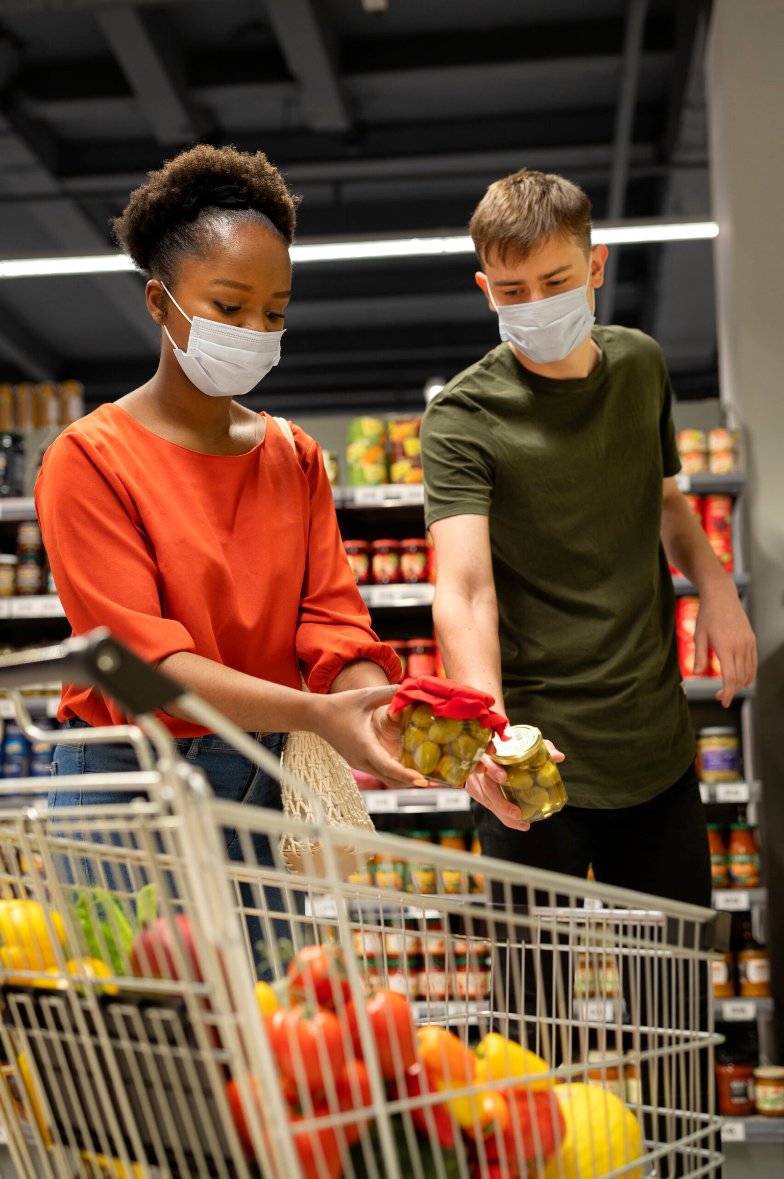 industries man woman with medical masks out grocery shopping with shopping cart